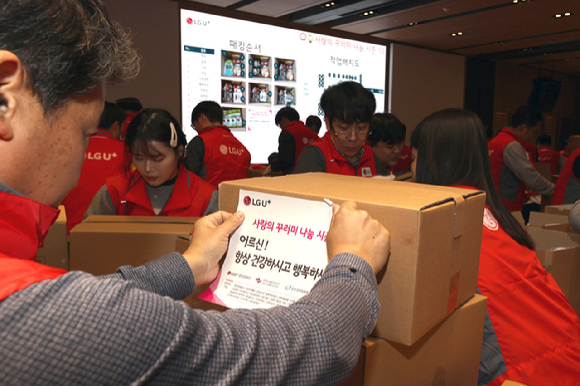 봉사자들이 사랑의 꾸러미 행사에서 상자를 포장하고 있다. [사진=LGU+]