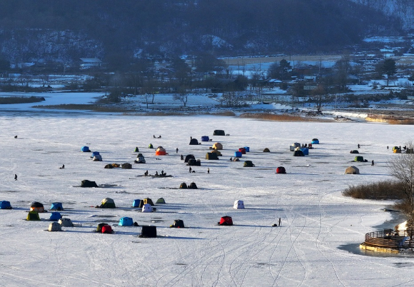 '빙박 명소'로 알려진 강원 춘천시 사북면 지촌리 인근의 얼어붙은 북한강 위로 캠핑을 즐기는 시민들의 텐트가 모여 있다. [사진=연합뉴스]