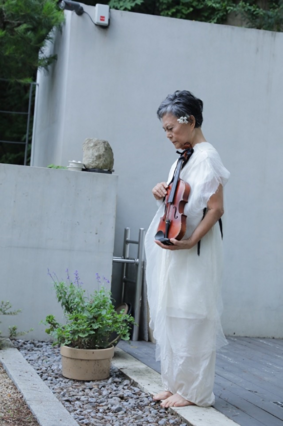 지난 7월 서울 평창동 운심석면에서 홍신자씨가 백남준 탄생 90주년 특별공연 중 바이올린 퍼포먼스를 펼치고 있다.[사진=홍신자 제공]