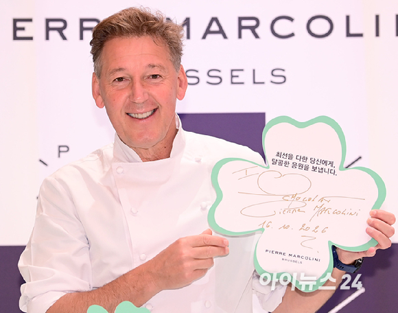 벨기에 초콜릿 브랜드 피에르 마르콜리니(Pierre Marcolini)가 수능을 앞둔 한국 수험생을 위한 시즌 한정 초콜릿 '그랑 클로버 셀렉션'을 출시한 가운데 16일 신세계백화점 강남점 스위트파크 내 피에르 마르콜리니 매장에서 브랜드 파운더 피에르 마르콜리니가 제품을 들고 포즈를 취하고 있다. [사진=정소희 기자]
