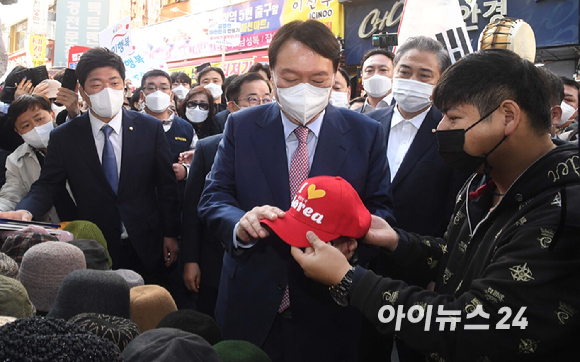 윤석열 국민의힘 대선 경선 후보가 3일 오전 서울 중구 남대문시장에서 모자를 고르고 있다. [사진=국회사진취재단]