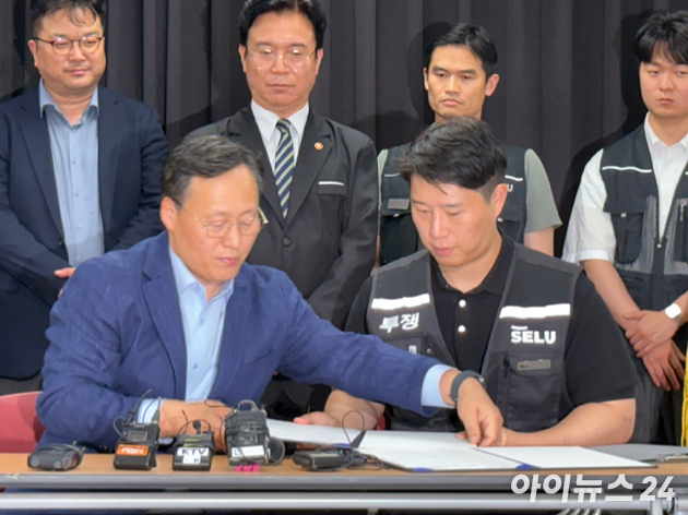 여명구 삼성전자 부사장(왼쪽)과 최승호 초기업노조 위원장이 수원 경기고용노동청에서 열린 성과급 제도 개편에 합의하고 서명하고 있다. [사진=권서아 기자]