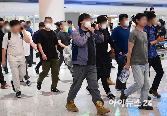 미국 이민당국에 의해 조지아주에 구금됐던 한국인 근로자들이 12일 인천국제공항 제2여객터미널 입국장을 나서고 있다. 작업복을 입은 상태로 귀국하는 근로자의 모습. [사진=정소희 기자]