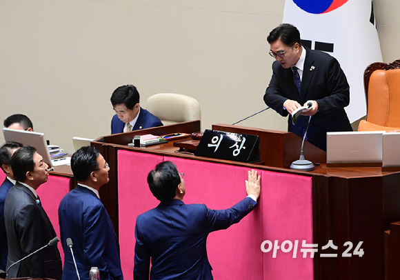 우원식 국회의장이 25일 서울 여의도 국회에서 열린 제429회 국회(정기회) 제9차 본회의에서 '민주유공자 예우 법률안 신속처리안건 지정동의의 건' 투표 중 명패와 투표지 갯수 1개차 불일치가 발생한 것에 대해 항의하는 송언석 국민의힘 원내대표에게 국회법을 보여주며 해결방안을 설명하고 있다. [사진=정소희 기자]