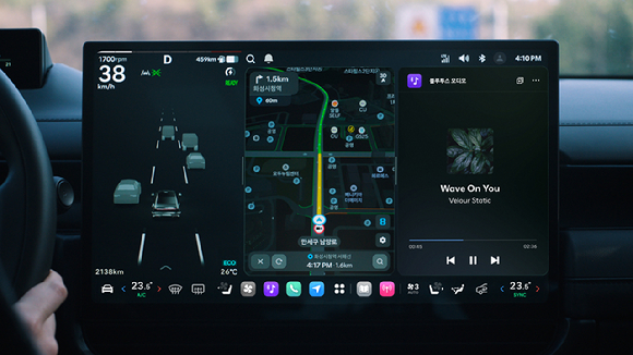 '플레오스 커넥트' 대화면 디스플레이. 왼쪽 '주행 정보 화면'에 주변의 객체와 차선 정보를 인식하는 모습이 표시되고 있다. 오른쪽 '앱 화면'은 내비게이션과 블루투스 오디오가 분할 화면으로 실행되고 있다. [사진=현대자동차그룹]
