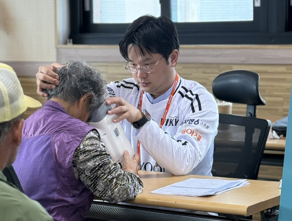 홍천군 주민이 실명질환 진단 기기 '위스키'와 안저카메라 '옵티나'를 통해 안저검진을 받고 있다. [사진=대웅제약 제공]