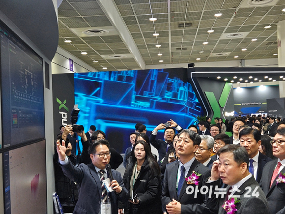 안덕근 산업통상자원부 등 주요 인사 18명이 12일 서울 강남구 코엑스에서 열린 일렉스(ELECS)코리아 2025 전시회에 마련된 부스 앞에서 설명을 듣고 있다. [사진=설재윤 기자]