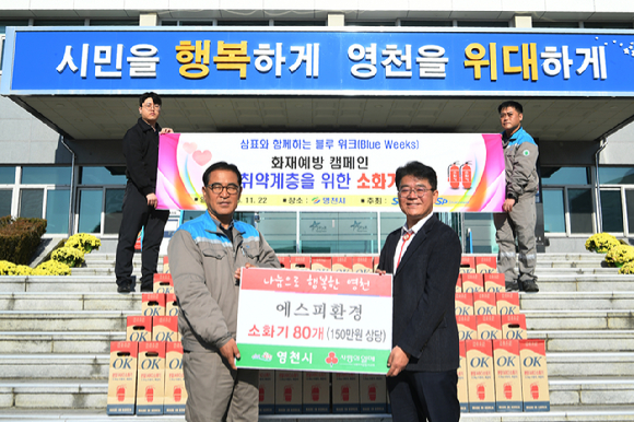 강병군 에스피환경 대표(왼쪽)가 영천시에 소화기를 전달한 후 김진현 영천시 부시장과 기념사진을 촬영하고 있다. [사진=삼표그룹]