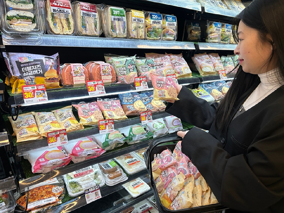 모델이 이마트24에서 트릭컬 리바이브 협업 상품을 둘러보고 있다. [사진=이마트24]