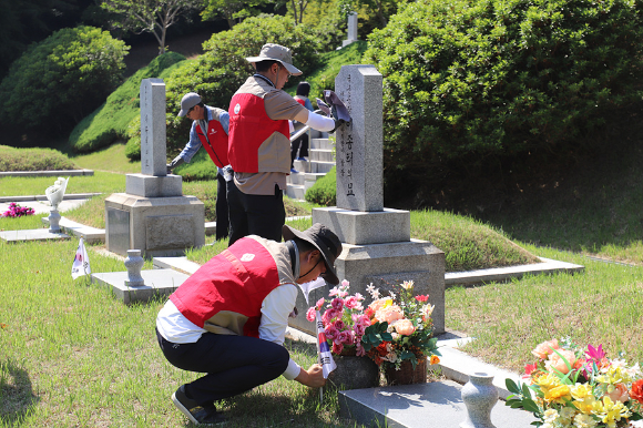 롯데이노베이트 임직원 봉사자들이 현충원 묘역 단장 봉사를 하고 있다. [사진=롯데이노베이트]