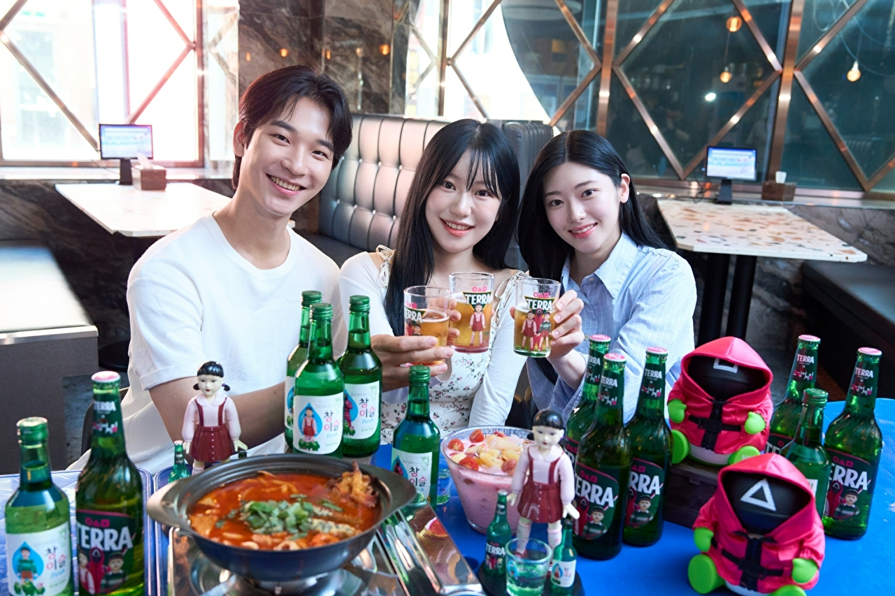 대학생들이 '테라·참이슬 오징어 게임 에디션' 제품과 굿즈를 함께 즐기고 있다 [사진=하이트진로 제공]