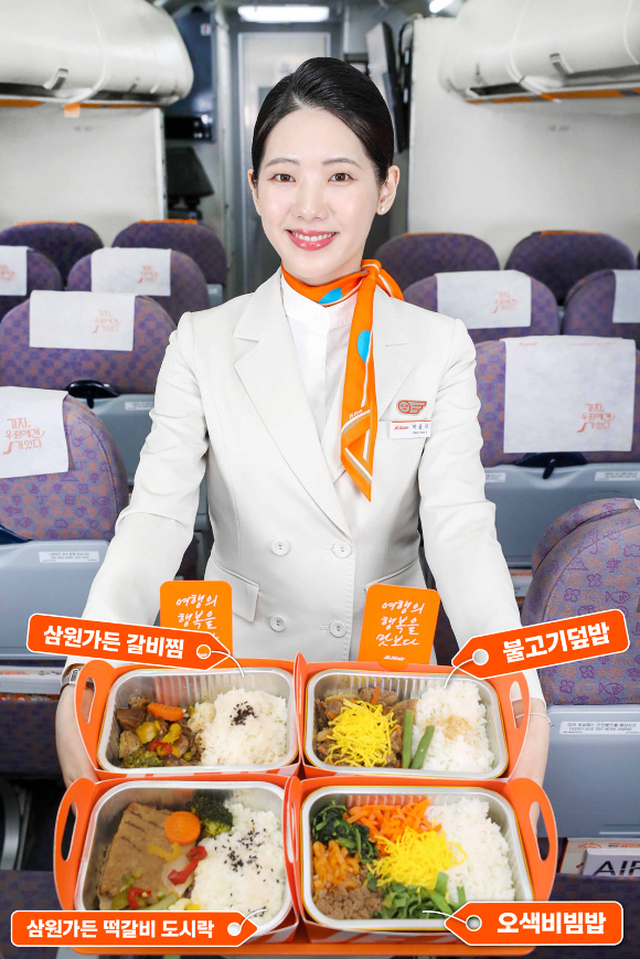 제주항공 객실승무원이 기내식 인기메뉴인 불고기덮밥, 오색비빔밥, 삼원가든 소갈비찜 도시락, 삼원가든 떡갈비 도시락 등을 들고 있다. [사진=제주항공]