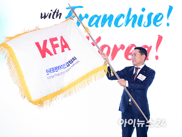 나명석 신임 한국프랜차이즈산업협회장(웰빙푸드 회장)이 19일 오후 서울 여의도 콘래드 서울 그랜드볼룸에서 열린 한국프랜차이즈산업협회 협회장 이&middot;취임식 및 비전 선포식에서 협회기를 흔들고 있다. [사진=정소희 기자]