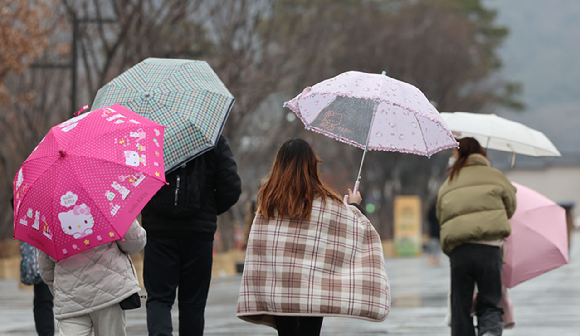  지난달 18일 오후 서울 종로구 광화문광장에서 시민들이 우산을 쓰고 이동하고 있다. [사진=뉴시스]