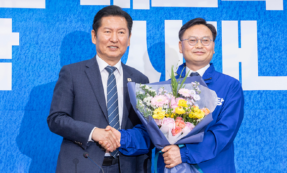 6&middot;3 재보선에서 제주 서귀포시에 출마할 것으로 예상되는 김성범 전 해양수산부 차관이 30일 국회에서 열린 더불어민주당 인재 영입식에서 정청래 대표에게 민주당의 상징 '파란 점퍼'를 받은 뒤 악수하고 있다. 2026.4.30 [사진=연합뉴스]