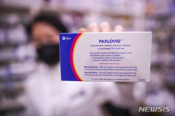 14일 서울시내 한 약국에서 약사가 경구용 코로나19 치료제 '팍스로비드'를 들어보이고 있다. [사진=뉴시스]