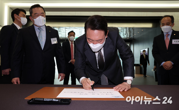 윤석열 대통령 당선인이 지난달 31일 서울 강남구 한국무역협회에서 열린 '청년무역 국가대표와의 만남'에 참석해 방명록을 작성하고 있다. [사진=인수위사진기자단]