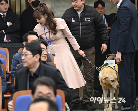 김예지 국민의힘 의원과 새 안내견 태백이가 27일 서울 여의도 국회에서 열린 의원총회에 참석하고 있다. [사진=곽영래 기자]