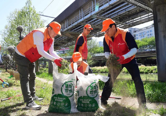 김성수 SK브로드밴드 사장(오른쪽) 등 임직원들이 24일 도림천 일대에서 환경 정화 및 생태계 복원을 위한 자원 봉사 활동을 진행했다. [사진=SKB]