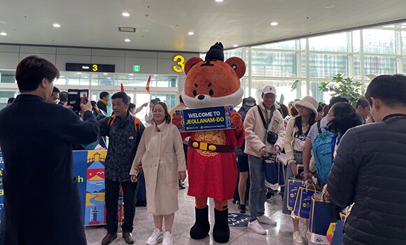 전라남도가 무안공항에 무사증으로 입국한 베트남 관광객에 대한 환영행사를 하고 있다. [사진=전남도]