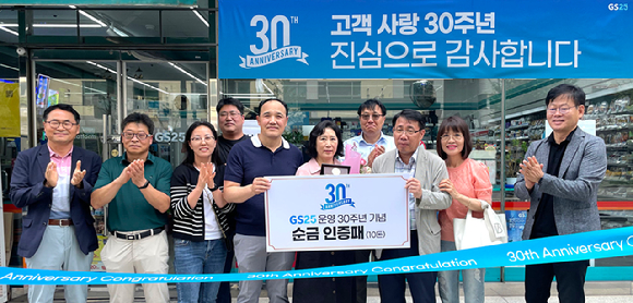 GS25는 지난 12일 GS25 신구로점을 30년 넘게 운영해 온 김정인자 경영주에게 30주년 기념 현판과 기념패를 증정했다. 김정인자 경영주(왼쪽부터 여섯번째)와 정재형 GS리테일 편의점사업부장(왼쪽부터 여덟번째)을 비롯한 관계자들이 기념촬영을 하고 있다. [사진=GS25]