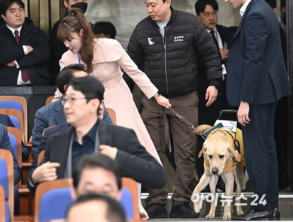 김예지 국민의힘 의원과 새 안내견 태백이가 27일 서울 여의도 국회에서 열린 의원총회에 참석하고 있다. [사진=곽영래 기자]