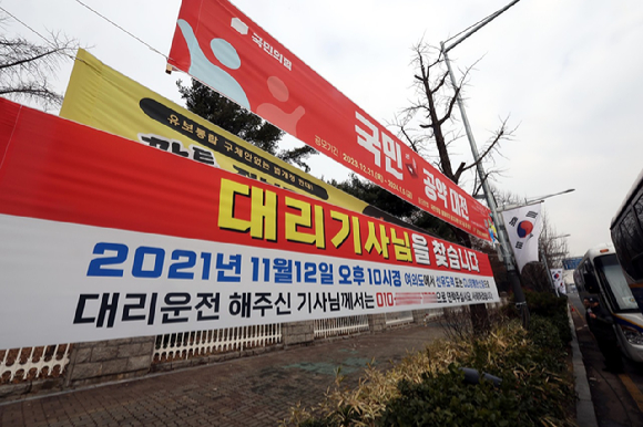  보복 운전 혐의로 1심 재판에서 벌금형을 선고받은 이경 전 민주당 상근부대변인이 자신에게 기소 의견을 낸 현직 경찰관 2명을 고소했다. 사진은 이 전 부대변인이 지난해 12월 29일 오전 서울 여의도 국회 앞에 게시한 '2021년 11월 12일 대리기사를 찾습니다"는 내용의 플래카드. [사진=뉴시스]