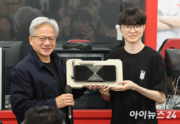 젠슨 황 엔비디아 최고경영자(CEO)가 5일 서울 마포구 &lsquo;T1 베이스 캠프&rsquo;를 방문해 &lsquo;페이커&lsquo; 이상혁을 비롯한 e스포츠 구단 T1의 리그 오브 레전드(LoL) 선수단을 만난 뒤 페이커 선수에게 받은 유니폼을 꺼내보고 있다. [사진=곽영래 기자]