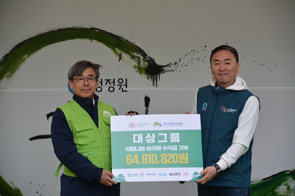 26일 청계광장에서 열린 2024 희망의 나무 나누기 행사에서 남태헌(왼쪽) 한국산림복지진흥원장과 임정배 대상주식회사 대표이사가 사랑나눔 바자회 수익금 기부 후 함께 기념 촬영하고 있다. [사진=한국산림복지진흥원/산림청]