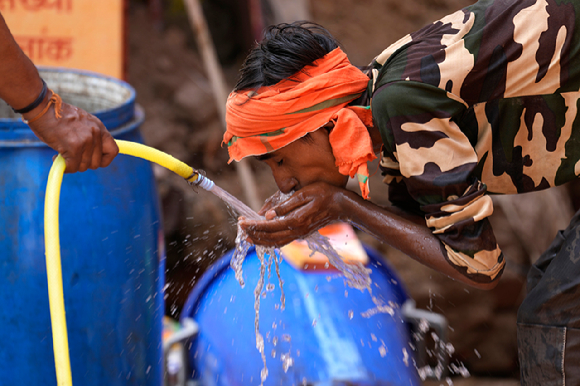 인도 우타르프라데시주 러크나우에서 한 남성이 호스에서 나오는 물을 받아 마시며 더위로 인한 갈증을 해소하고 있다. 인도의 낮 최고 기온이 50도에 육박하는 등 서아시아 지역에 기록적 고온 현상이 나타나고 있다. [사진=뉴시스]