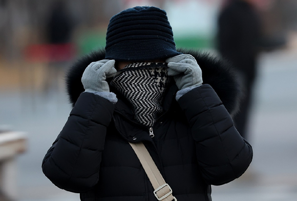 강추위 날씨가 이어진 가운데 서울 종로구 광화문광장 인근에서 한 시민이 방한용품을 착용하고 있다. [사진=연합뉴스]