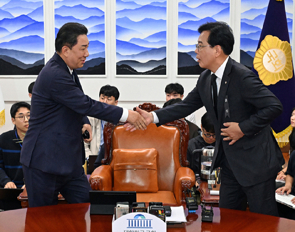 더불어민주당 김병기 원내대표(왼쪽)과 국민의힘 송언석 원내대표가 지난달 13일 국회에서 우원식 국회의장 주재로 열린 여야 교섭단체 원내대표 회동에서 만나 악수하고 있다. [사진=연합뉴스]