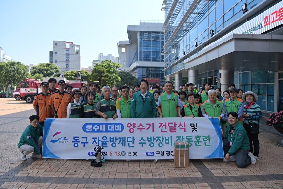 김진홍 부산광역시 동구청장(가운데)과 자율방재단원, 재난 담당 공무원 등이 풍수해 대비 양수기 작동 훈련을 실시하고 기념촬영을 하고 있다. [사진=부산광역시 동구]