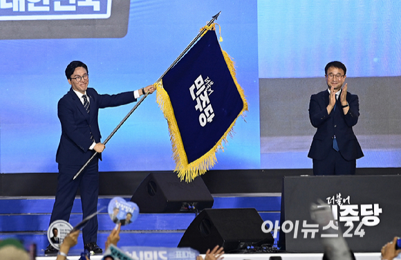 김민석 더불어민주당 신임 당 대표가 17일 대전 컨벤션센터에서 열린 제3회 더불어민주당 정기 전국당원대회에서 당 대표로 선출된 뒤 당기를 흔들고 있다. [사진=곽영래 기자]