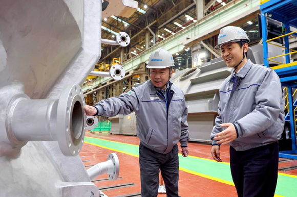 박정원 두산그룹 회장(왼쪽)이 지난 11일, 경남 창원 두산에너빌리티 사업장을 방문해 제작 중인 발전용 가스터빈 제품을 살펴보고 있다. [사진=두산에너빌리티]