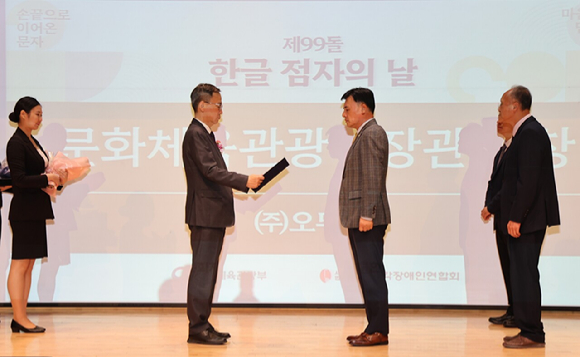 지난 4일 열린 '제99돌 한글 점자의 날 기념식'에서 문화체육관광부 김영수 차관(왼쪽에서 두 번째)이 오뚜기 황성만 대표이사에게 문체부 장관 표창을 수여하고 있다. [사진=오뚜기]