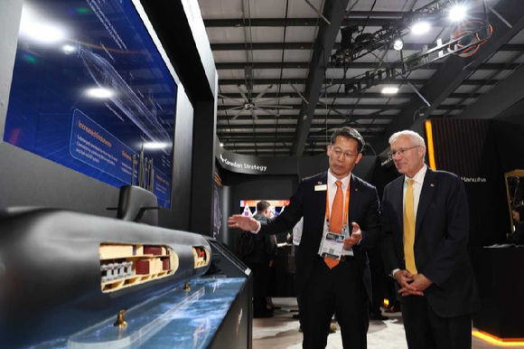 캐나다 오타와에서 열린 &lsquo;CANSEC 2026&rsquo; 전시회 내 한화오션 부스에서, 한화오션 특수선해외사업단장 정승균 부사장(왼쪽)이 빅터 피델리 온타리오주 경제개발부 장관에게 최신예 잠수함인 KSS-III 모델을 소개하며 그 우수성을 설명하고 있다. [사진=한화오션]