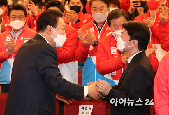 윤석열 제20대 대통령 당선인이 10일 새벽 서울 여의도 국회도서관에 마련된 '국민의힘 제 20대 대통령선거 개표상황실'을 찾아 안철수 국민의당 대표와 인사하고 있다. [사진=김성진 기자]