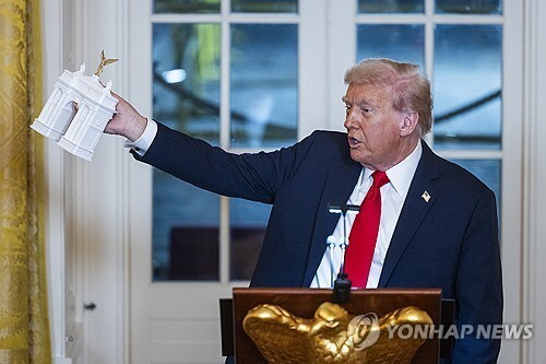 워싱턴 개선문 모형 들어올린 트럼프 대통령. [사진=UPI 연합뉴스 자료사진]