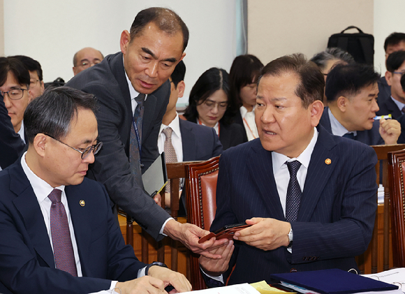 이상민(오른쪽) 행정안전부 장관이 7일 오전 서울 여의도 국회에서 열린 행정안전위원회의 행정안전부 등에 대한 국정감사에서 고기동(왼쪽) 차관 등 관계자와 휴대전화를 보며 대화하고 있다. 2024.10.07. [사진=뉴시스]