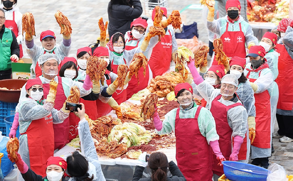 대구 동구 아양아트센터 앞에서 열린 '2025 사랑플러스 김장 나눔' 행사에서 새마을부녀회 등 500여명이 김장 김치를 들고 기념 촬영을 하고 있다. [사진=연합뉴스]