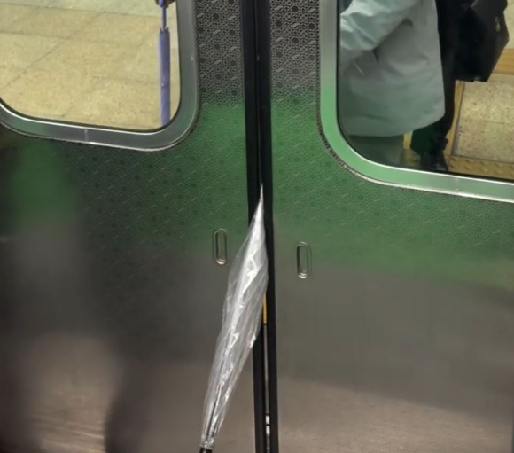 지하철 탑승에 실패할 것을 대비해 출입문 사이에 우산을 끼워 넣은 승객의 행동이 거센 비판을 받고 있다. 사진은 지하철 출입문 사이에 우산을 끼워넣은 승객 모습. [사진=온라인 커뮤니티]