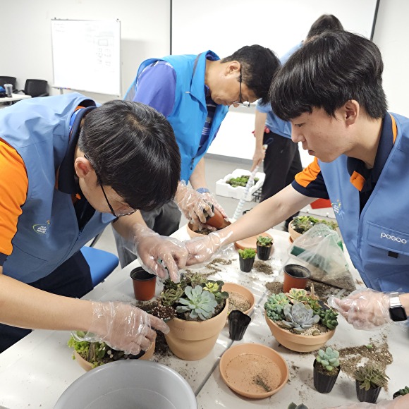 포항제철소 인턴사원들이 지역아동센터에 전달할 다육화분을 꾸미고 있다. [사진=포스코]