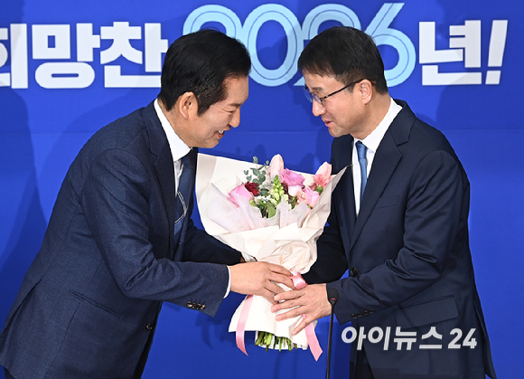 더불어민주당 정청래 대표가 12일 서울 여의도 국회에서 열린 최고위원회의에서 한병도 신임 원내대표에게 꽃다발을 전달한 뒤 기념 촬영하고 있다. [사진=곽영래 기자]