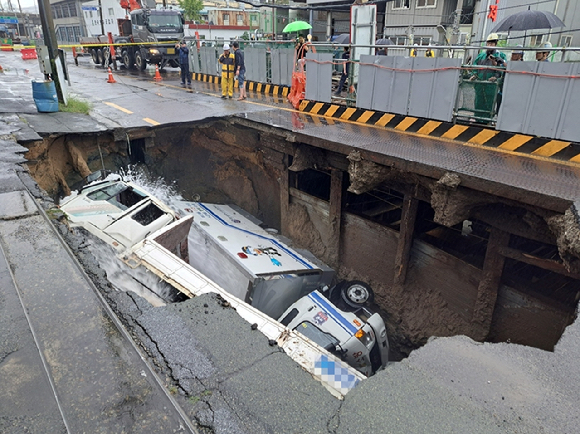 21일 오전 부산 사상구 새벽로 인근 도로에서 가로 10m·세로 5m, 깊이 8m 규모의 땅꺼짐이 발생해 차량 두 대가 빠졌다. (사진=부산소방재난본부 제공) 2024.09.21. [사진=뉴시스]