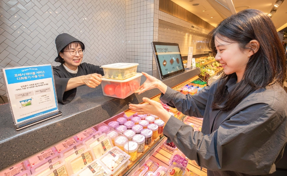 현대백화점 식품관에서 개인 다회용기를 가져와 과일 등을 손질해 주는 프레시 테이블 서비스를 이용하고 있다. [사진=현대백화점]