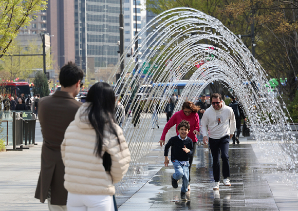 지난 15일 서울 광화문광장에서 관광객들이 분수터널을 지나고 있다. [사진=연합뉴스]