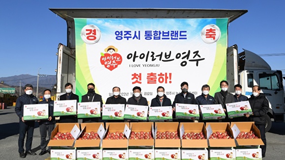 14일 영주농산물유통센터에서 장욱현(왼쪽 일곱번째) 영주시장과 관계자들이 국내 대형유통시장으로 납품할 사과 75톤 물량의 선적식을 갖고 '아이러브 영주'의 새 디자인 박스를 들어보이고 있다. [사진=영주시]