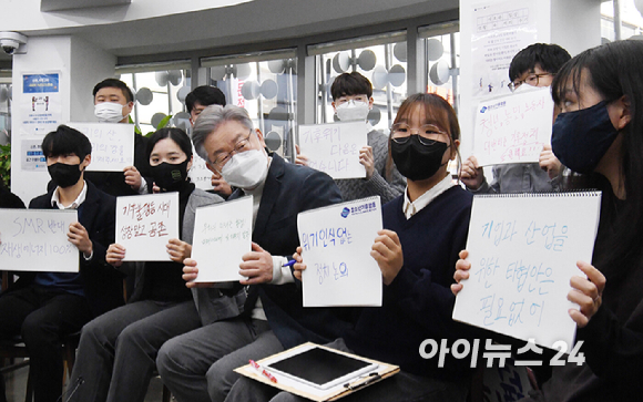 이재명 더불어민주당 대선후보가 16일 오전 서대문구 청년문화공간 신촌 파랑고래에서 청소년 청년 기후활동가들과 기후위기를 주제로 간담회를 가졌다. 이 후보가 간담회에 앞서 구호가 적힌 손팻말을 들고 있다. [사진=국회사진취재단]