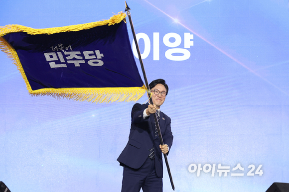 김민석 더불어민주당 신임 당 대표가 17일 대전 컨벤션센터에서 열린 제3회 더불어민주당 정기 전국당원대회에서 당 대표로 선출된 뒤 당기를 흔들고 있다. [사진=곽영래 기자]